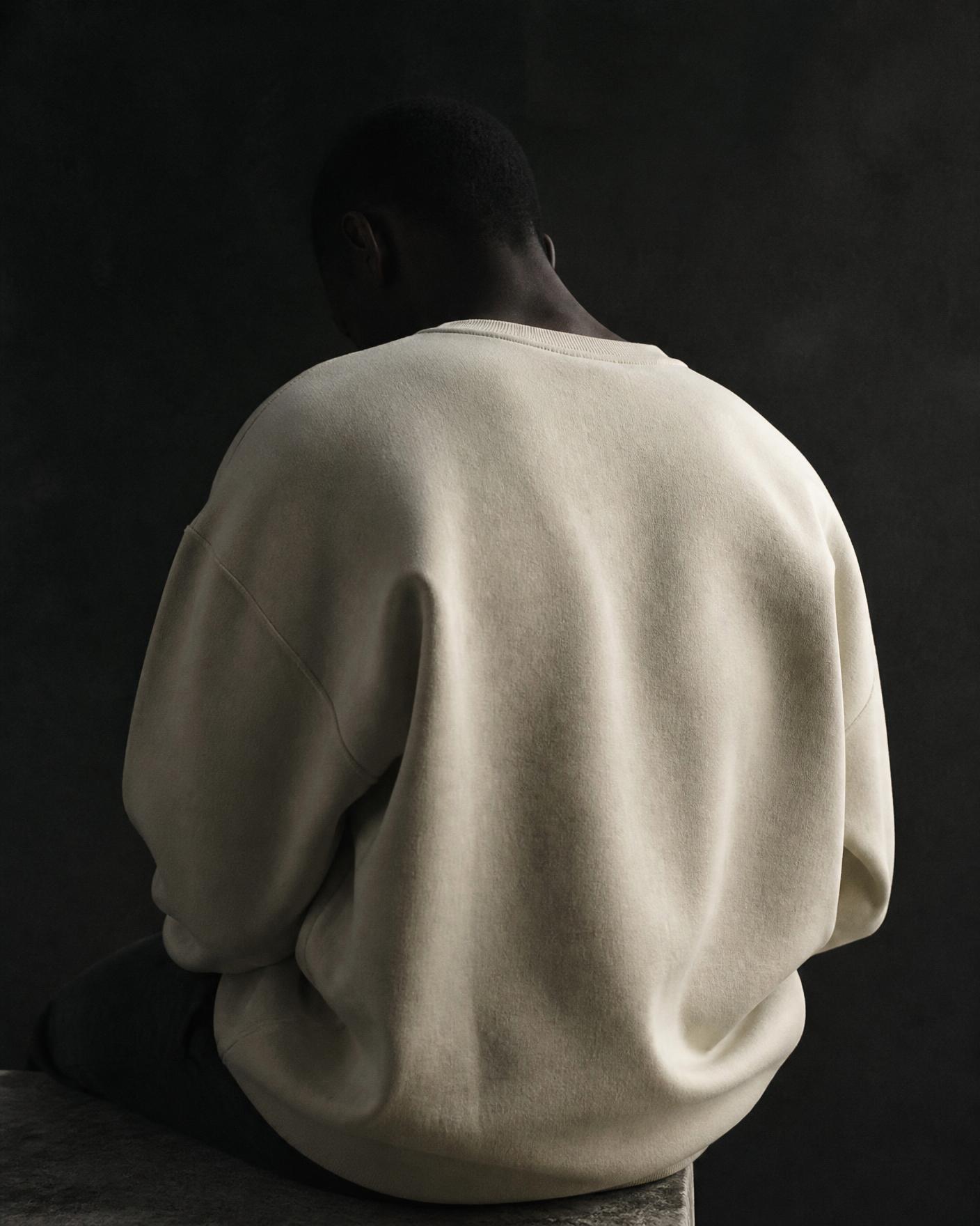 Model wearing a cream heavyweight crewneck from Holato Drop 001